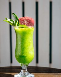 Tropical frozen drink with and umbrella and mint garnish